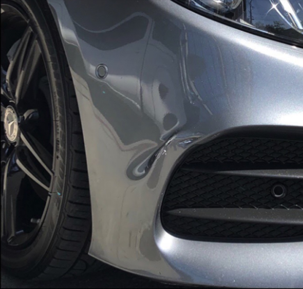 Front Bumper Repair before in Brea, CA, Deep front bumper dent on a Mercedes, reshaped, refinished, and PPG color-matched on-site in Orange County.